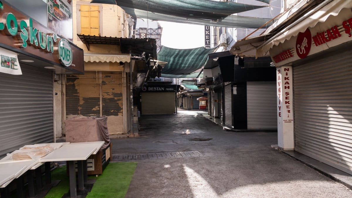 A quiet, empty alley in an İzmir bazaar with closed shops and awnings overhead.