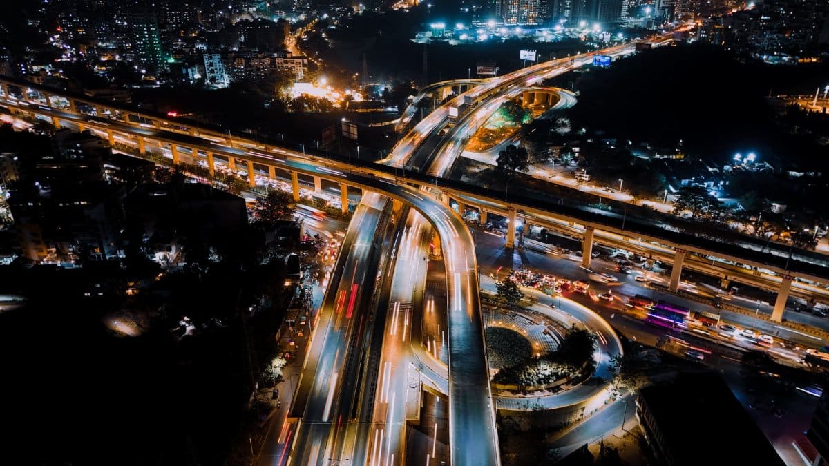A stunning aerial photograph capturing a bustling city interchange illuminated at night.