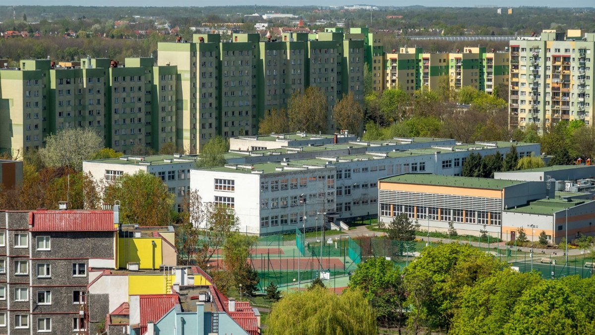 Aerial photograph of residential blocks and school in Wrocław, Poland, during daytime in spring.