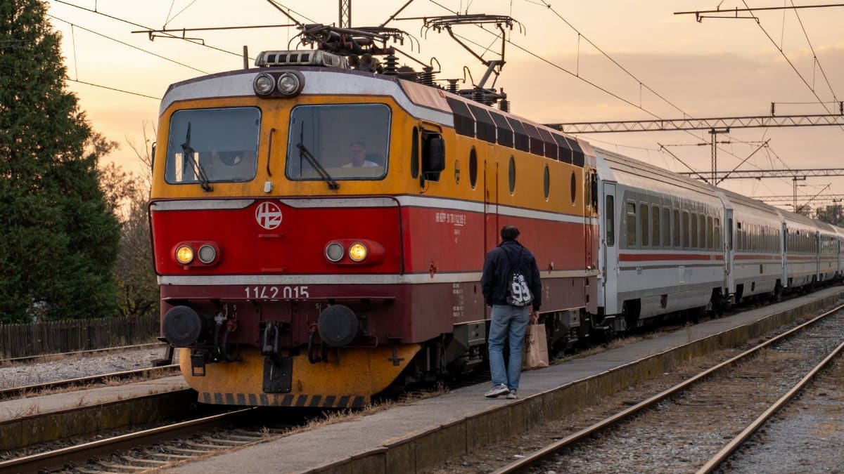 A passenger boards a vintage train at sunset in Kutina, Croatia. Scenic travel moment.