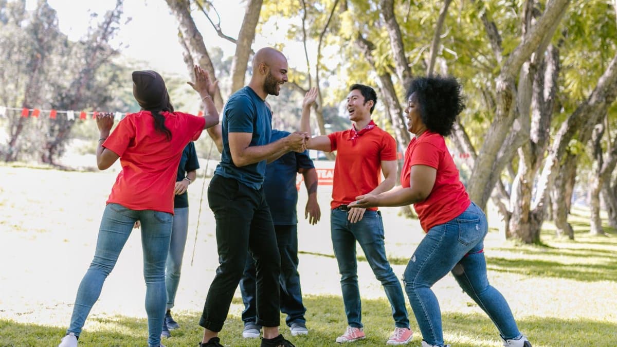A group of diverse adults enjoying a team building exercise outdoors.