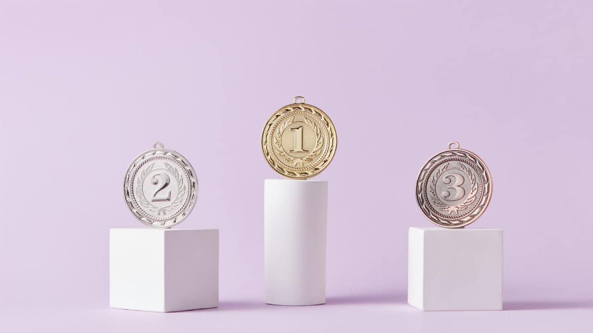 Medals on a podium against a soft pastel background, ideal for awards themes.