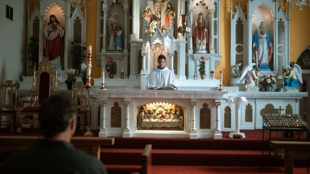 A priest conducts mass at a beautifully decorated church altar, engaging the congregation.