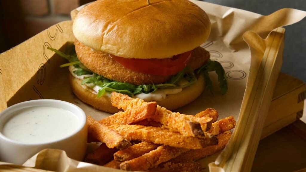 Delicious gourmet burger with a side of crispy sweet potato fries and creamy ranch dip.
