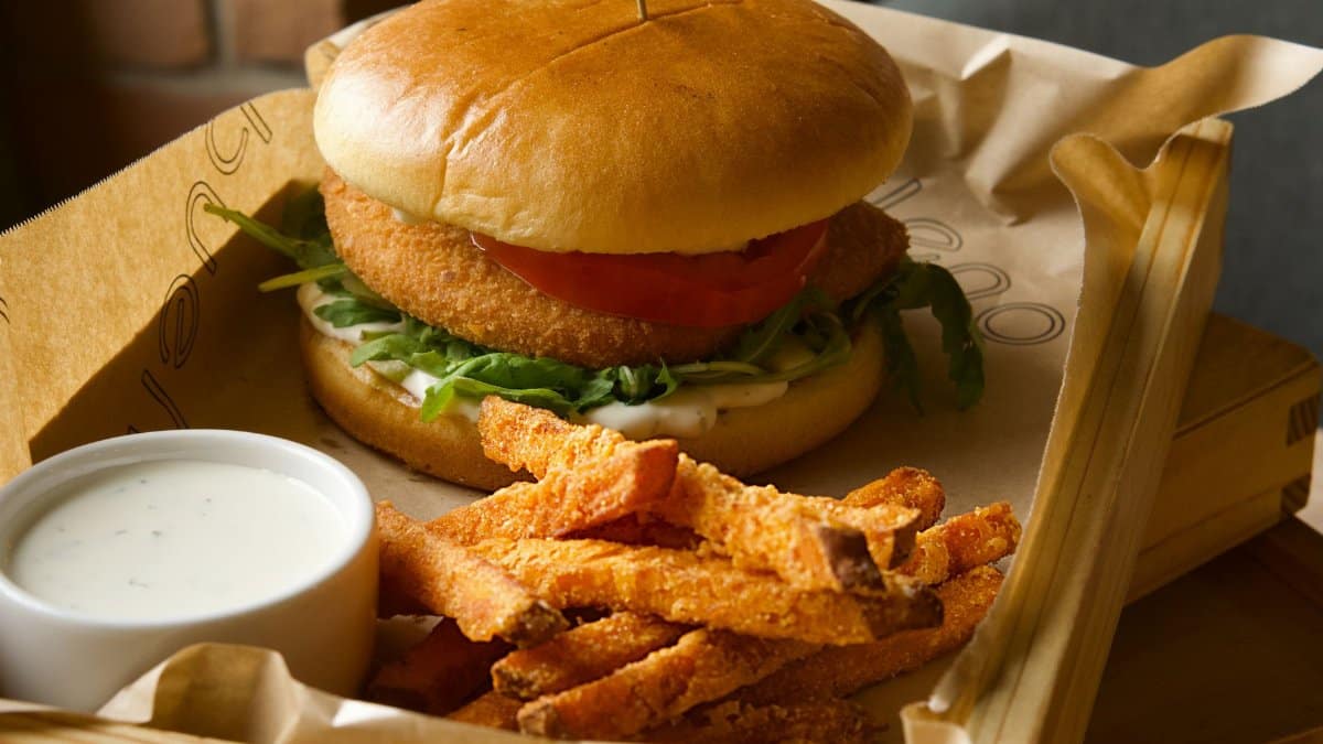 Delicious gourmet burger with a side of crispy sweet potato fries and creamy ranch dip.