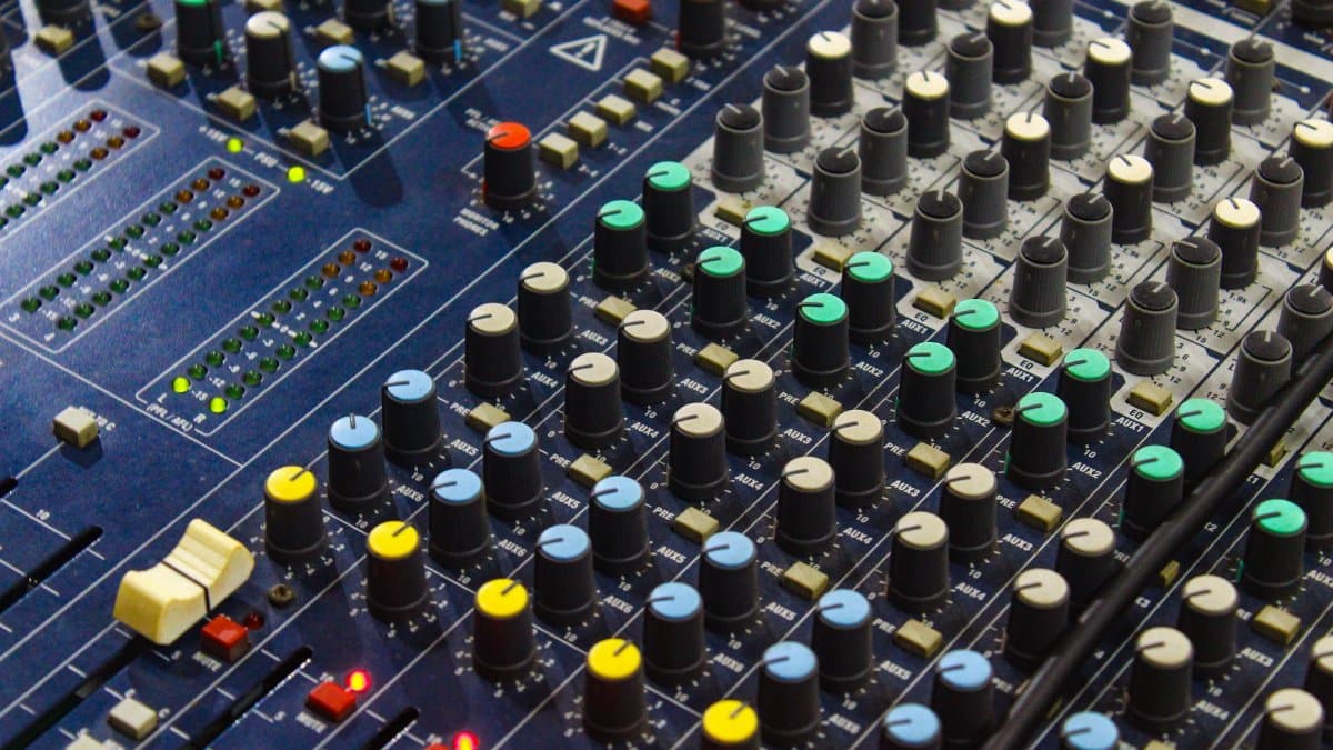 Close-up of a detailed audio mixer board with diverse controls and sliders.