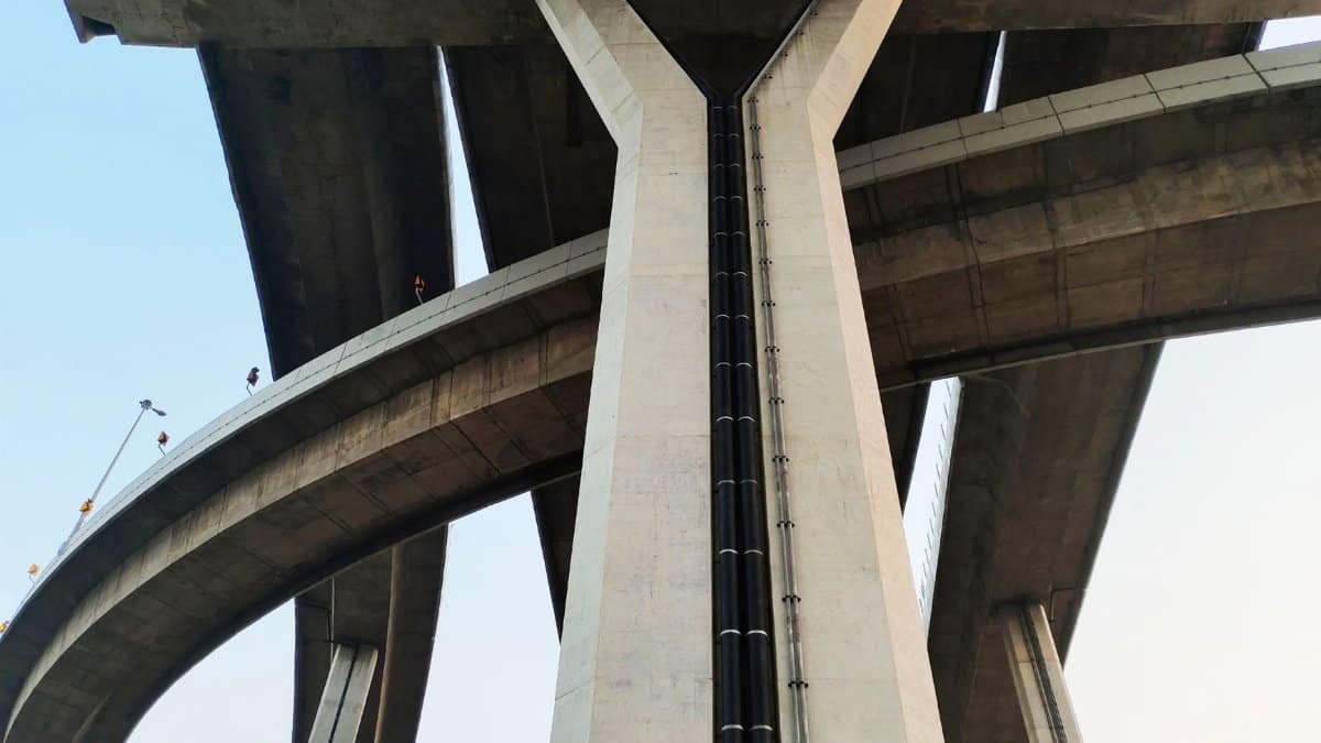 Low-angle shot of a modern concrete bridge in Bangkok, showcasing infrastructure design.