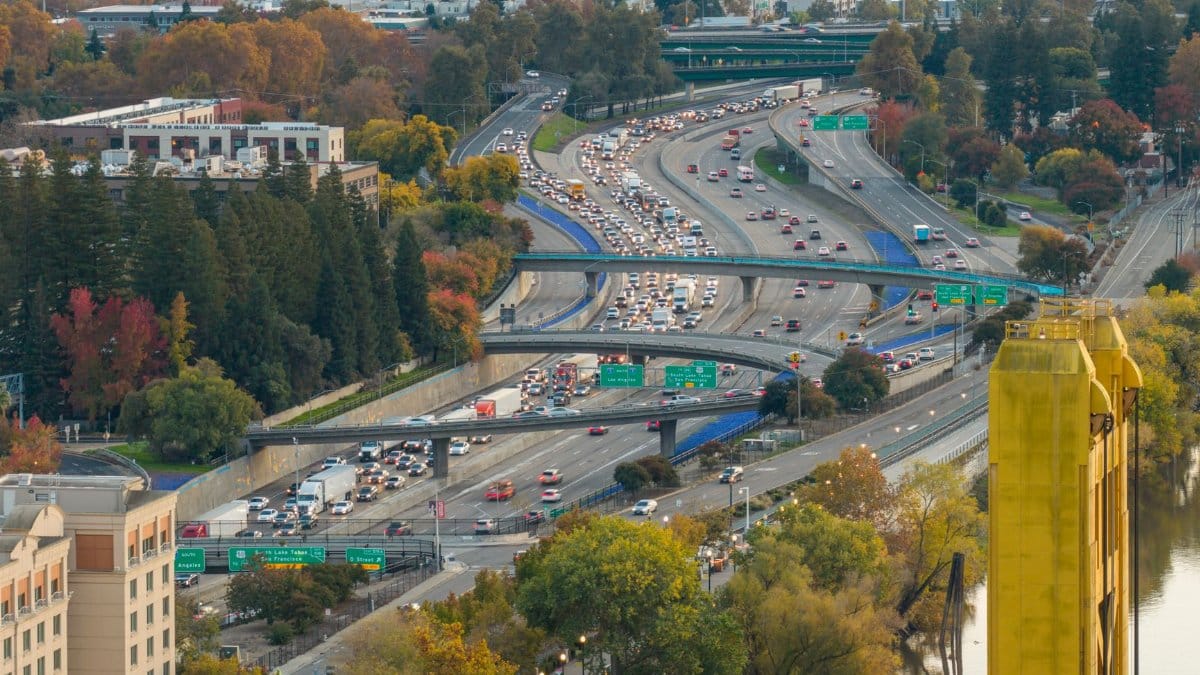 Aerial view of freeway traffic near Tower Bridge, Sacramento, showcasing fall foliage.