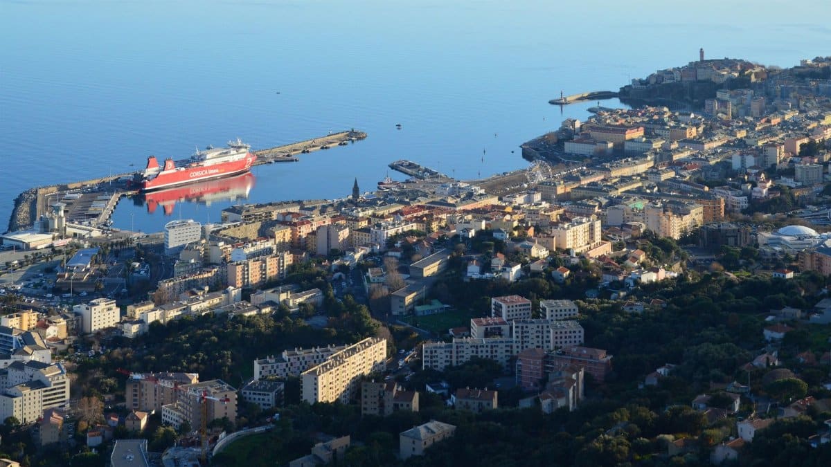 High-angle shot of Bastia Harbor and cityscape in Corsica, featuring a ferry docked at the port.