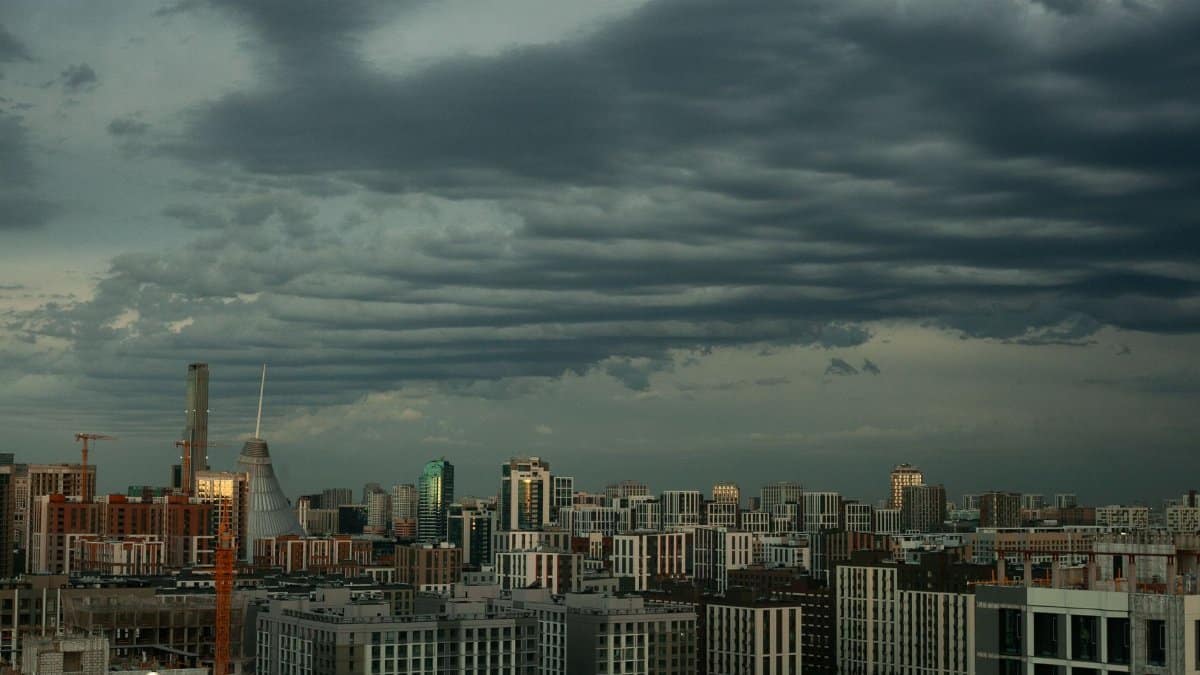 A cityscape under dramatic cloud formations, showcasing urban architecture.
