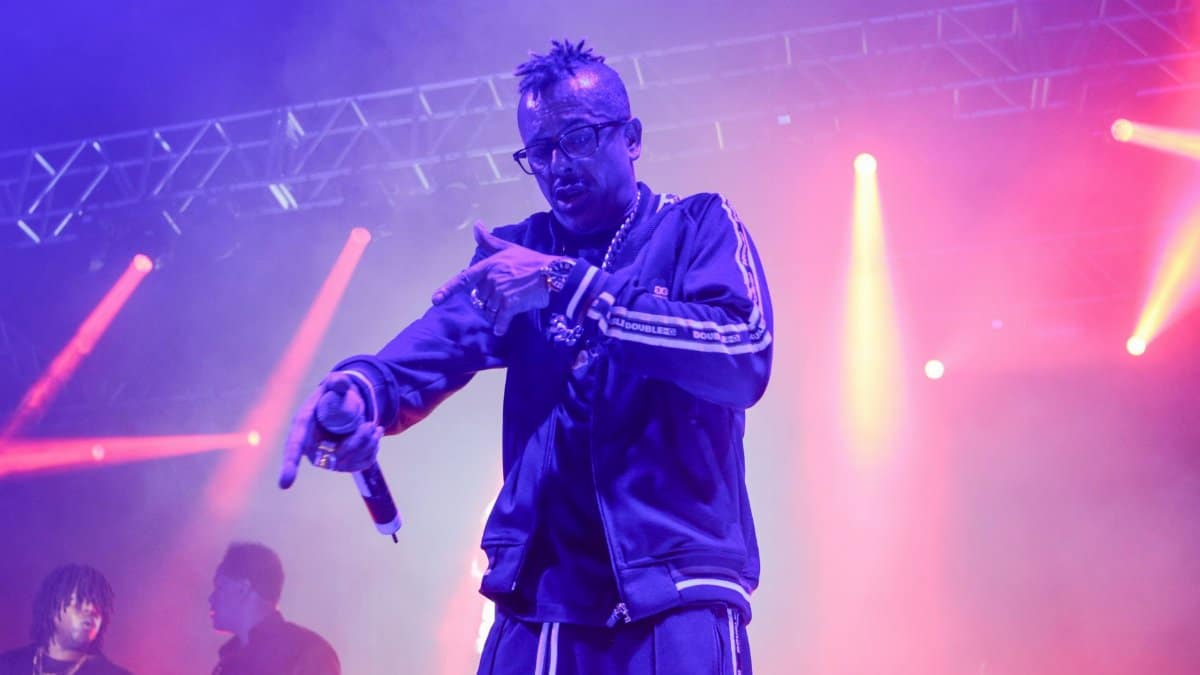 Vibrant live rap concert with performer on stage under colorful lights.