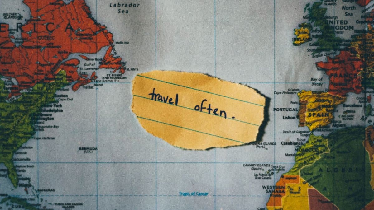 A motivating note 'travel often' placed over a colorful world map, inspiring exploration.