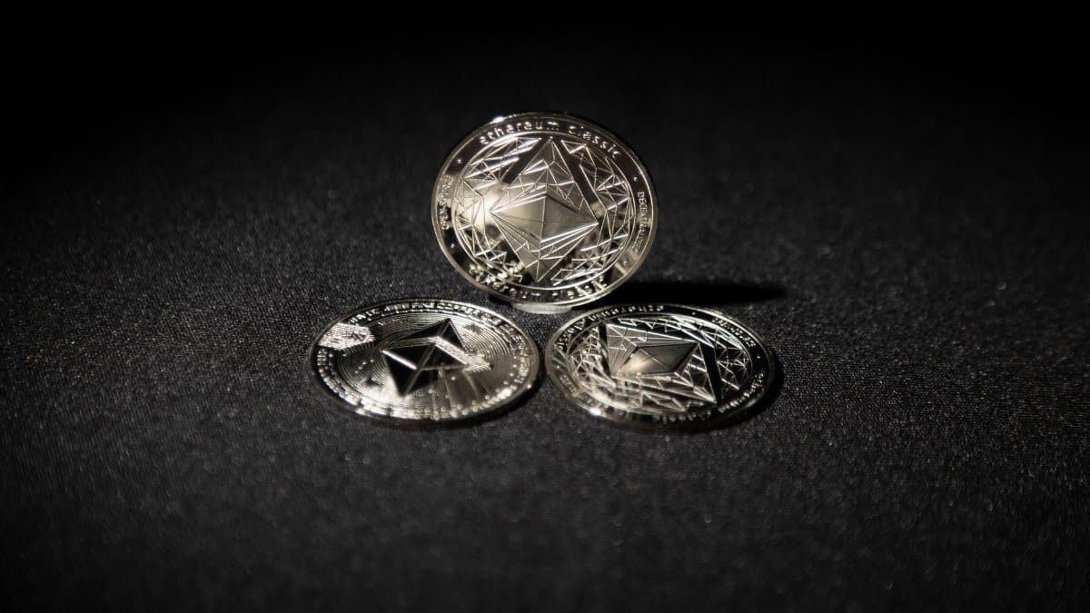 Close-up of three Ethereum coins on a dark background, showcasing digital currency themes.