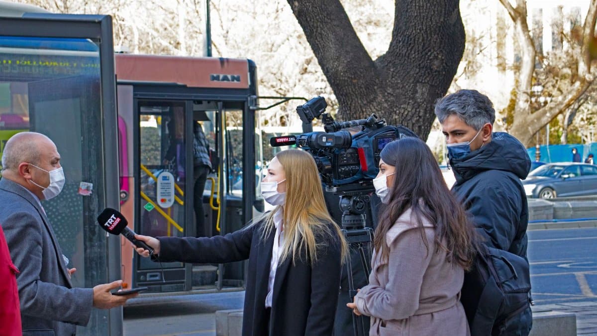Journalists conduct a street interview in Ankara, capturing the pandemic's impact on daily life.