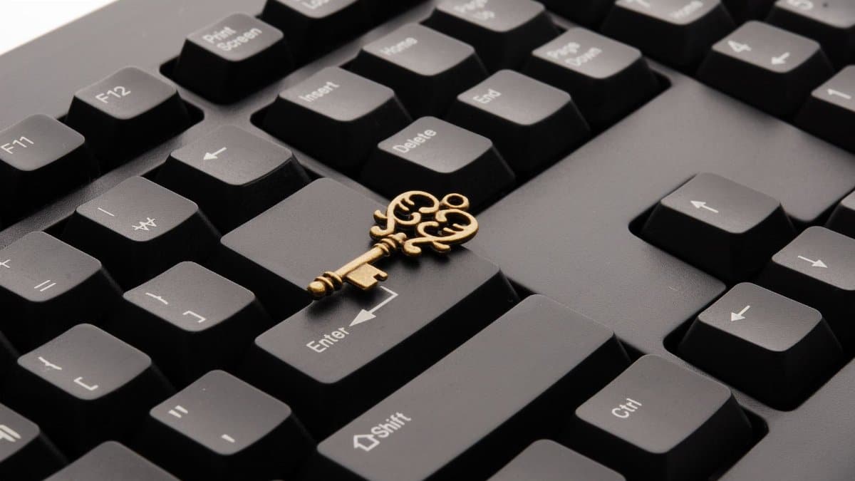 Close-up of an ornate vintage key placed on a modern computer keyboard.
