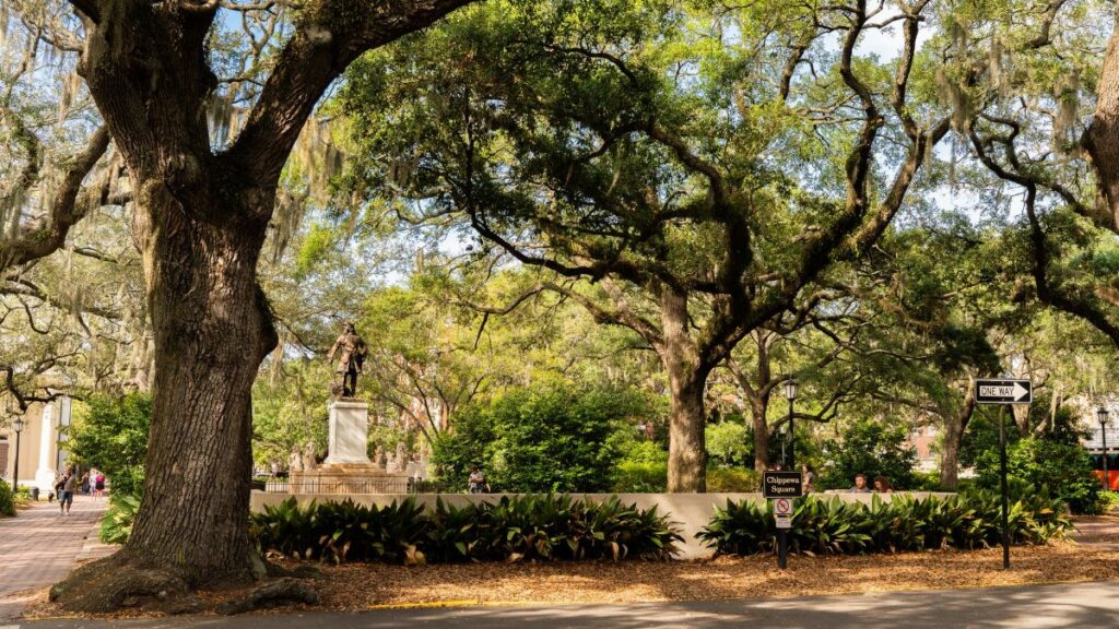 View of Chippewa Square in Savannah featuring lush live oaks and historical architecture.