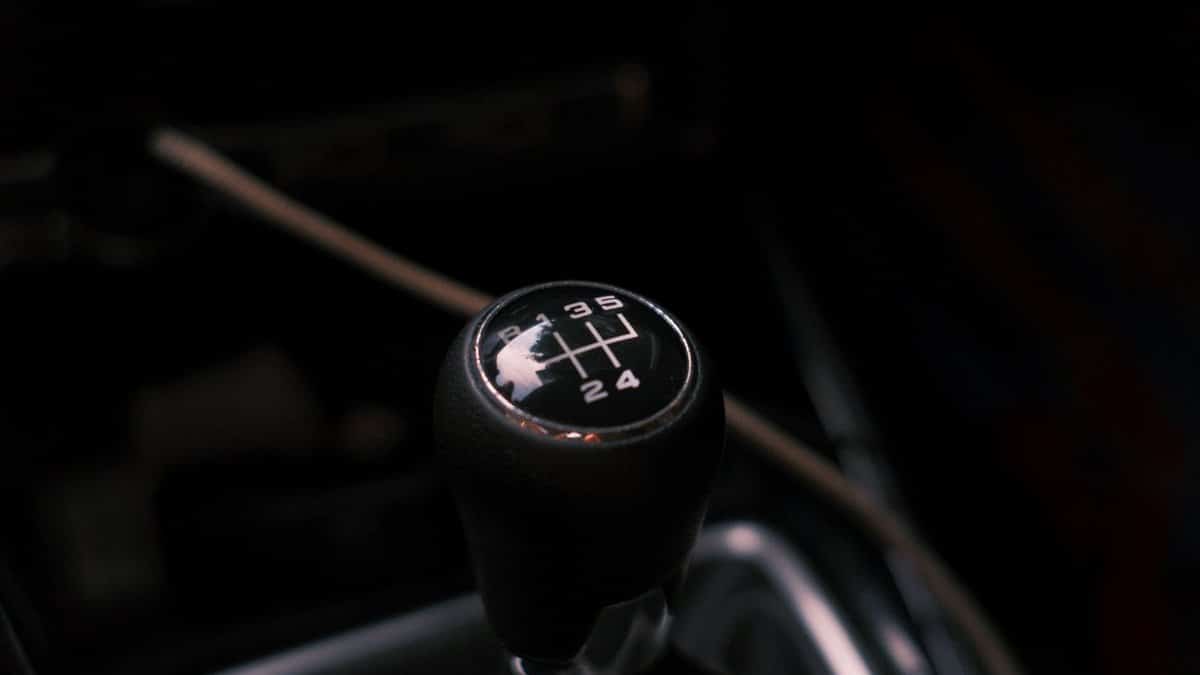 Detailed view of a car's manual transmission shift knob with visible gear pattern.
