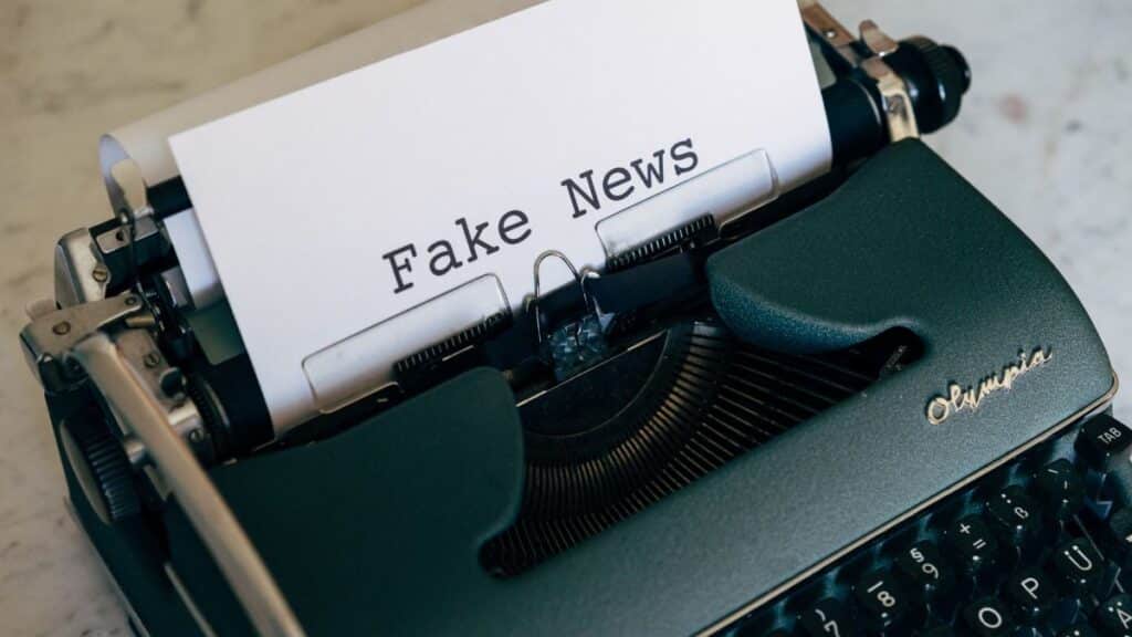 Close-up of a vintage typewriter displaying the words 'Fake News' on paper.
