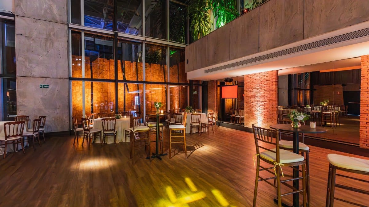 Spacious modern banquet hall with elegant decor and ambient lighting, ready for a celebratory event.