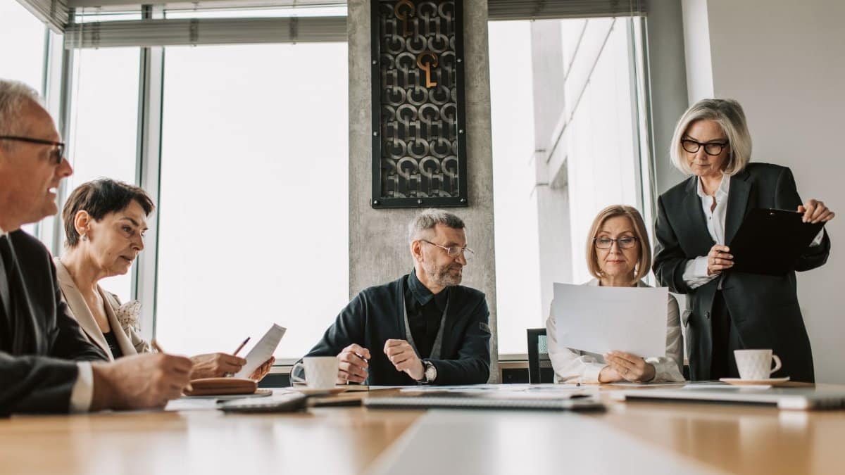 Business professionals discussing documents in a modern meeting room.