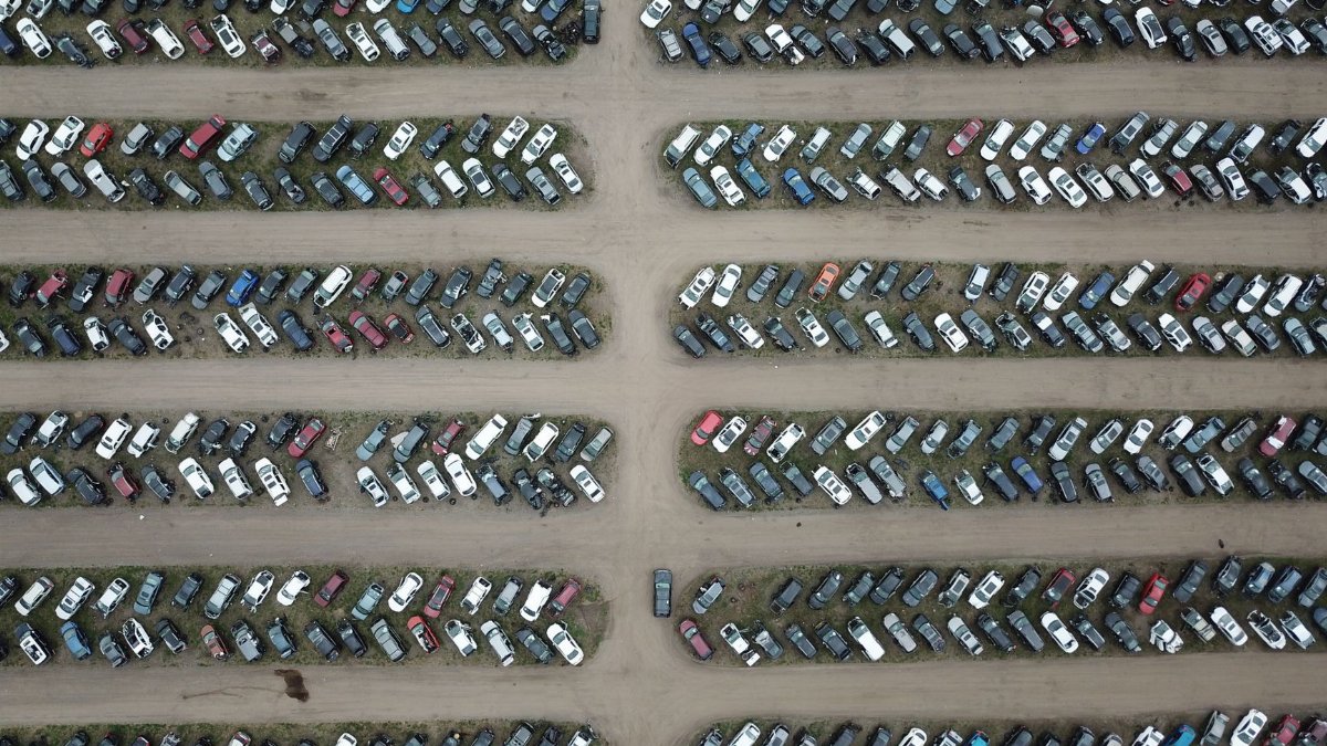High angle view of numerous vehicles in an organized car lot, showcasing variety and structure.