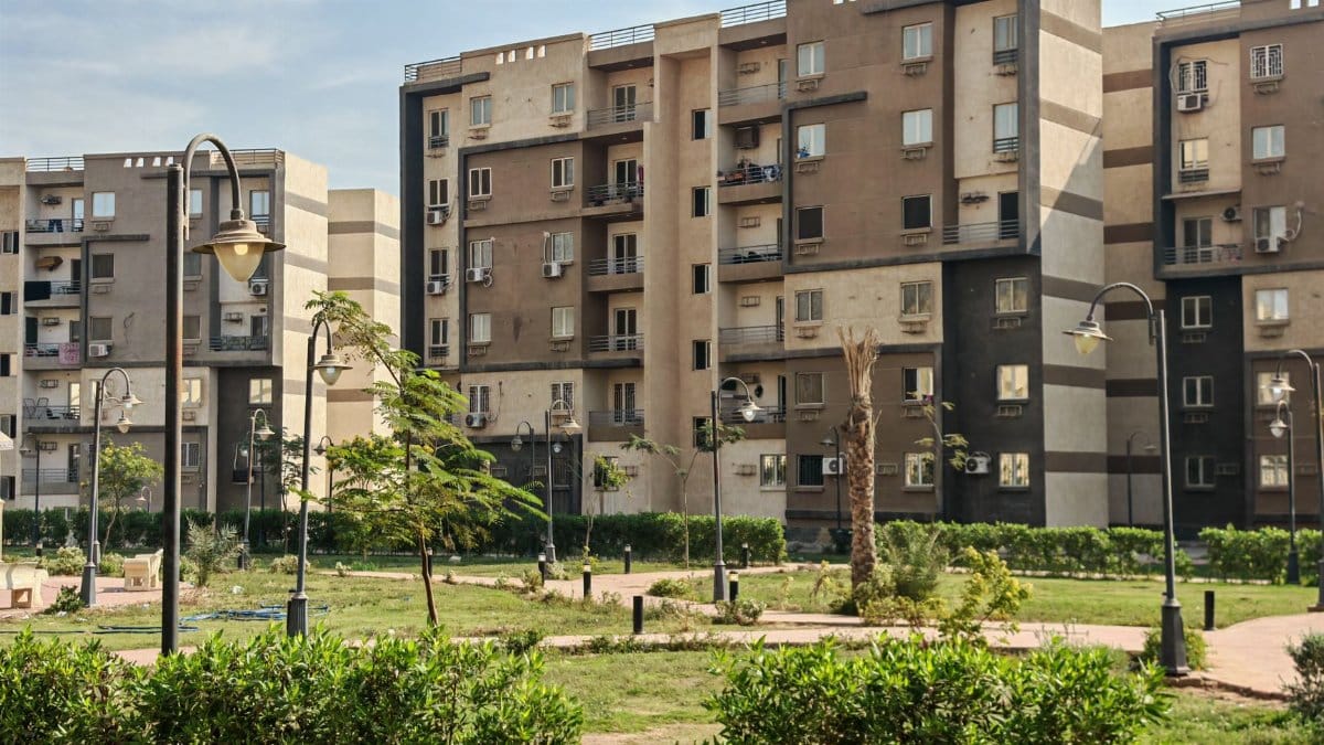 A modern residential building complex with lush greenery and public park.