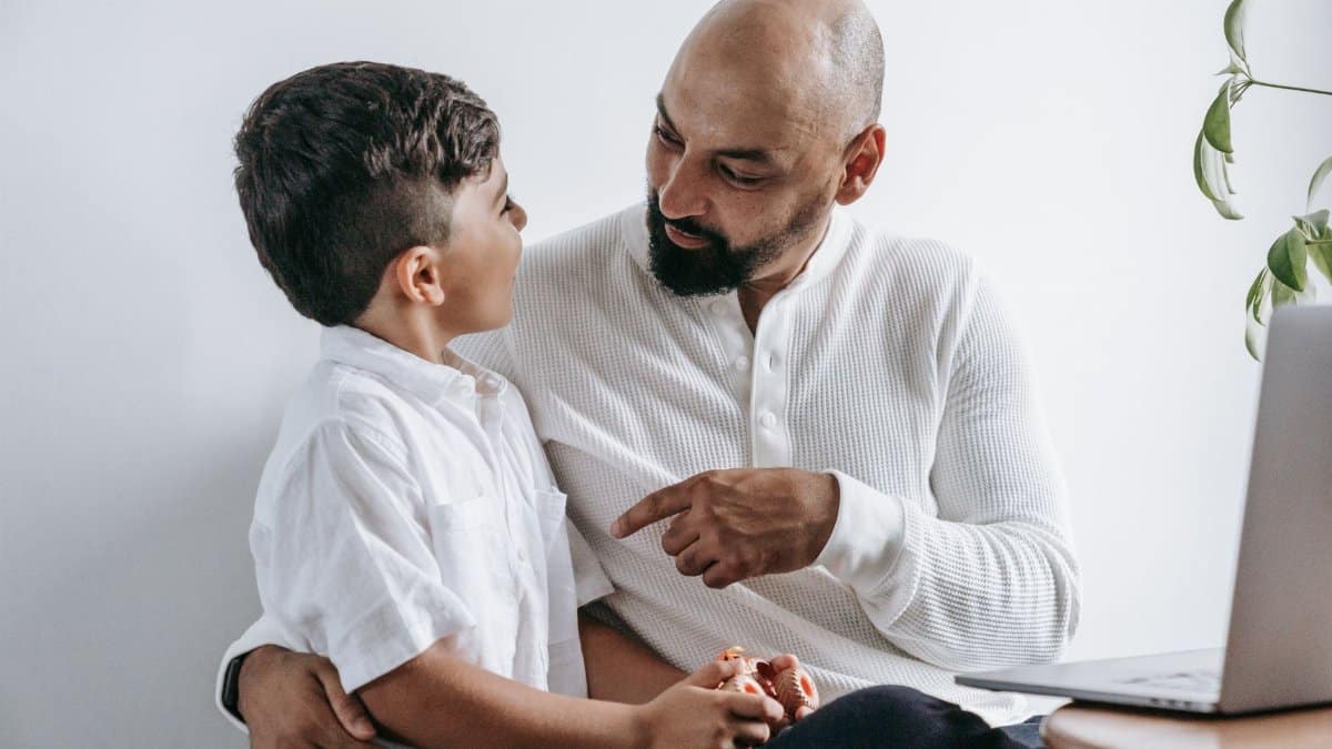 A touching scene of a father and son engaging in a deep conversation at home.