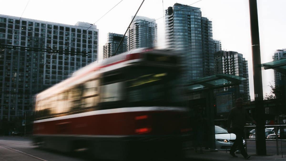 Blurred motion of a tram rushing through a modern urban landscape with skyscrapers.
