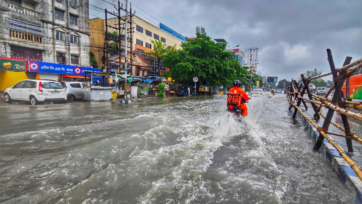 A motorcyclist rides through waterlogged streets in Kolkata during the monsoon season.