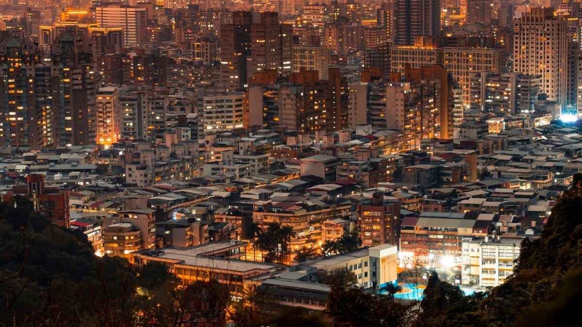 Stunning aerial view of a vibrant city at night showcasing illuminated skyscrapers and architecture.