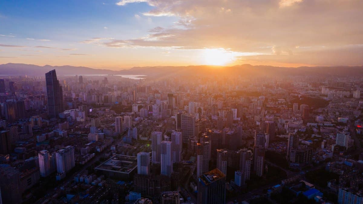 Aerial view of a bustling city with skyscrapers at sunset, showcasing modern architecture.