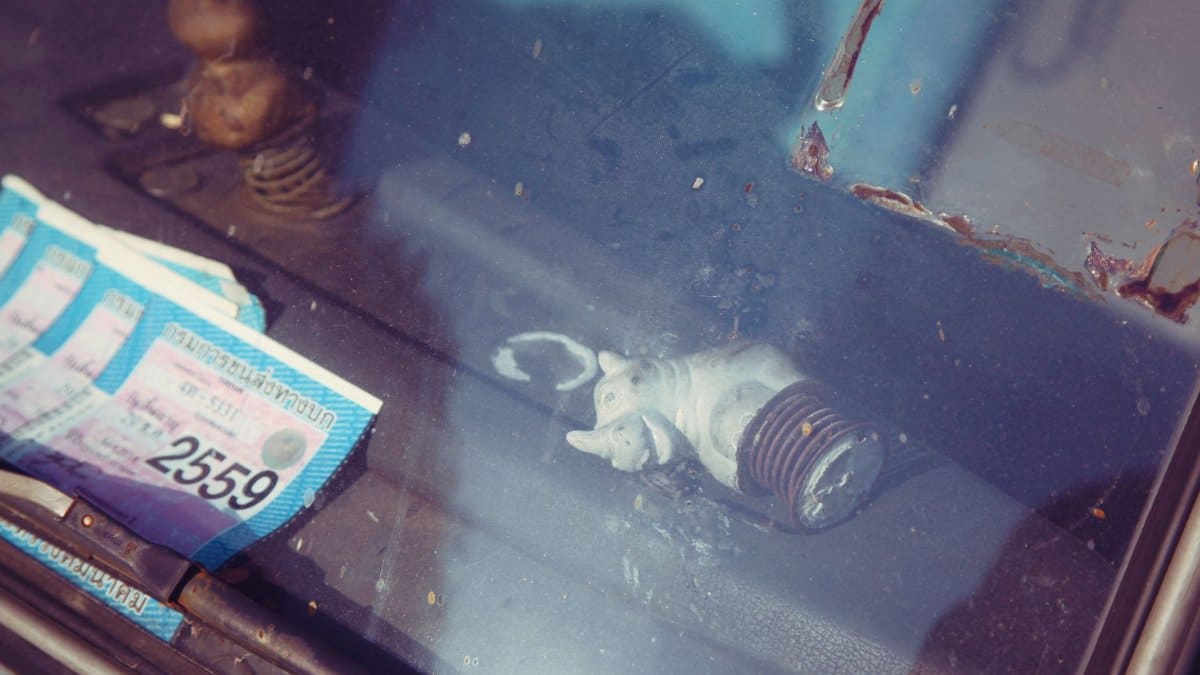 From above through scratched car front window of permit papers and rhinoceros statuette