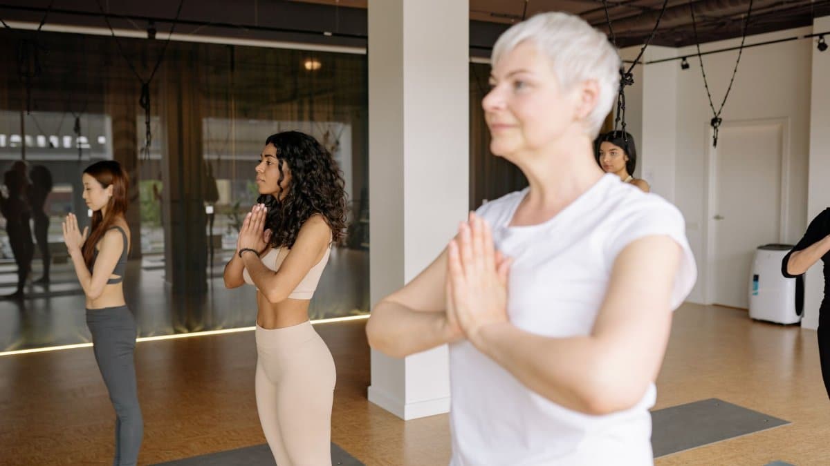 Women of different ages and ethnicities participating in a yoga class indoors, showcasing diversity and wellness.