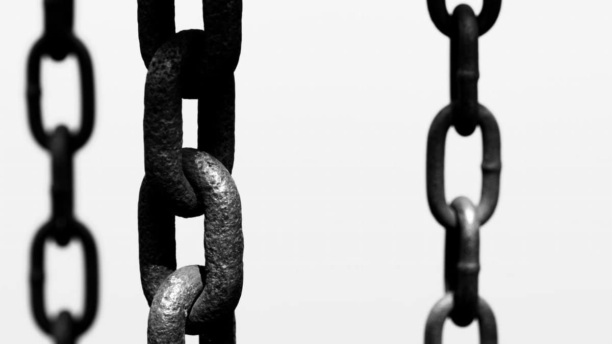 Artistic black and white photo of hanging chains, focusing on texture and connection.