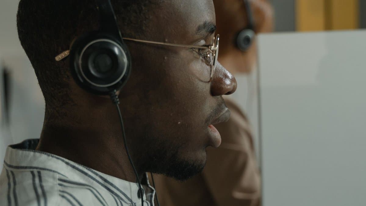 Side view of a focused customer service representative wearing a headset in a call center.