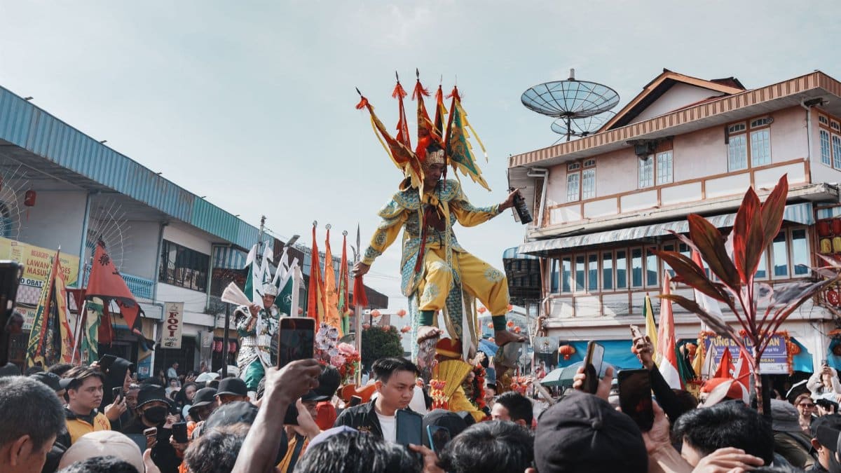Vibrant traditional festival parade in Singkawang, West Kalimantan, featuring colorful costumes and crowd.