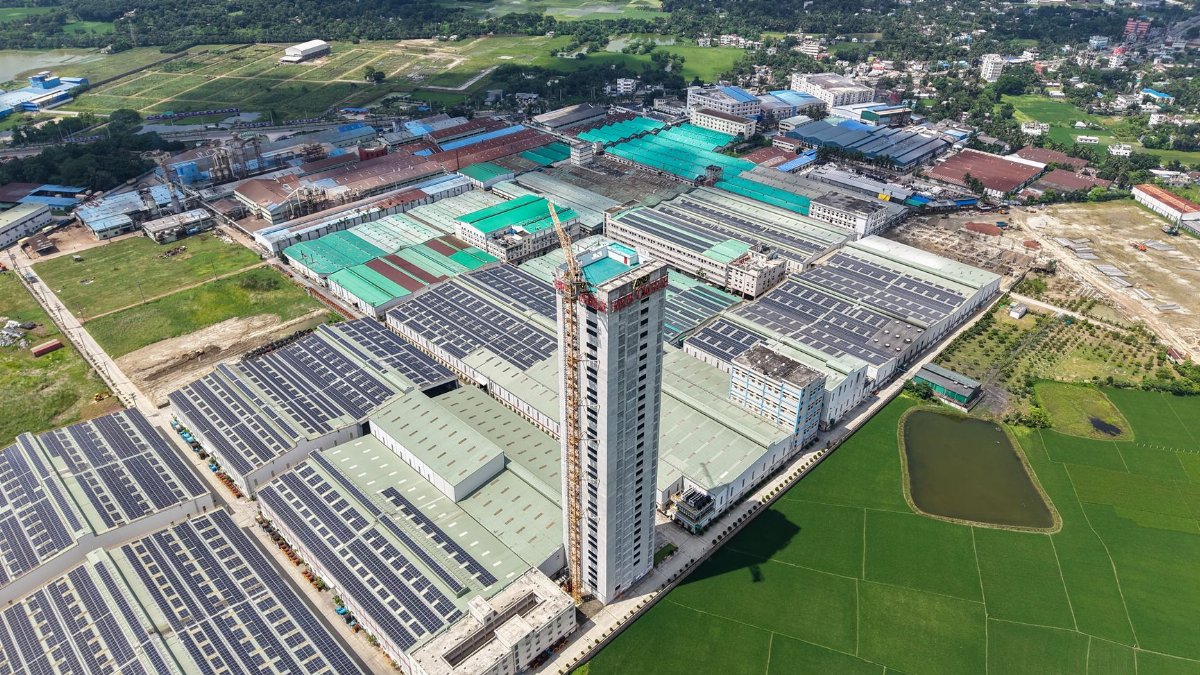 Aerial view of a large industrial factory complex and green fields.