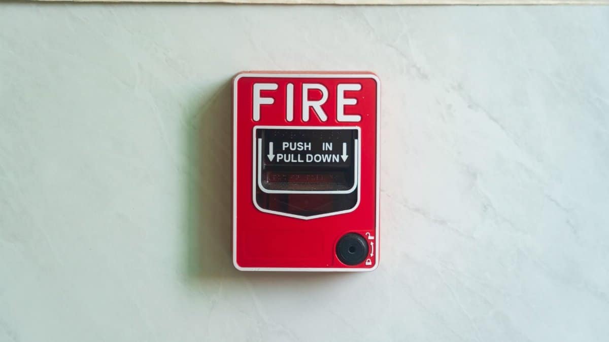 Image of a wall mounted red fire alarm device for safety alerts and emergency preparedness.