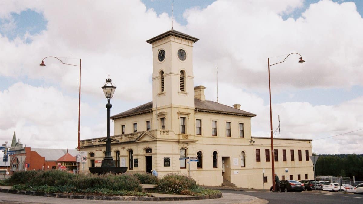 Charming historic clock tower building at a roundabout, capturing urban architecture and classic design.