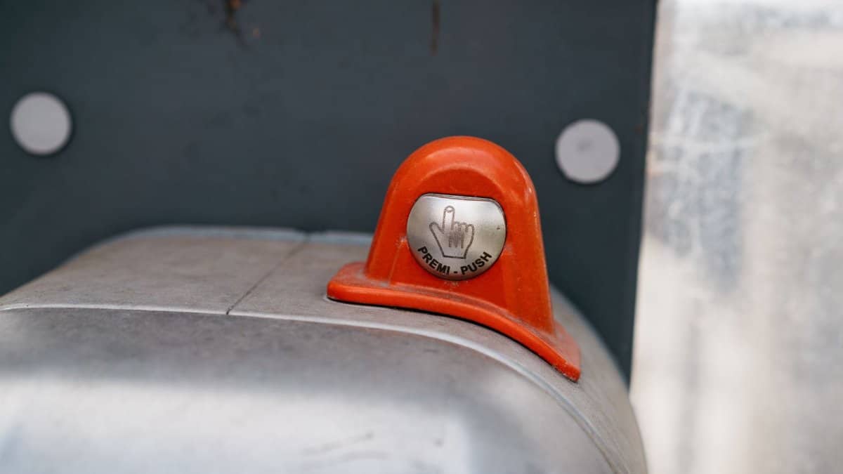 A detailed image of an orange industrial push button labeled 'Premi-Push.'
