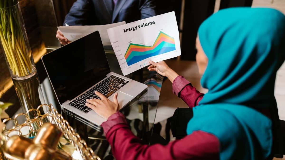 Muslim woman analyzing energy volume data during a business meeting.