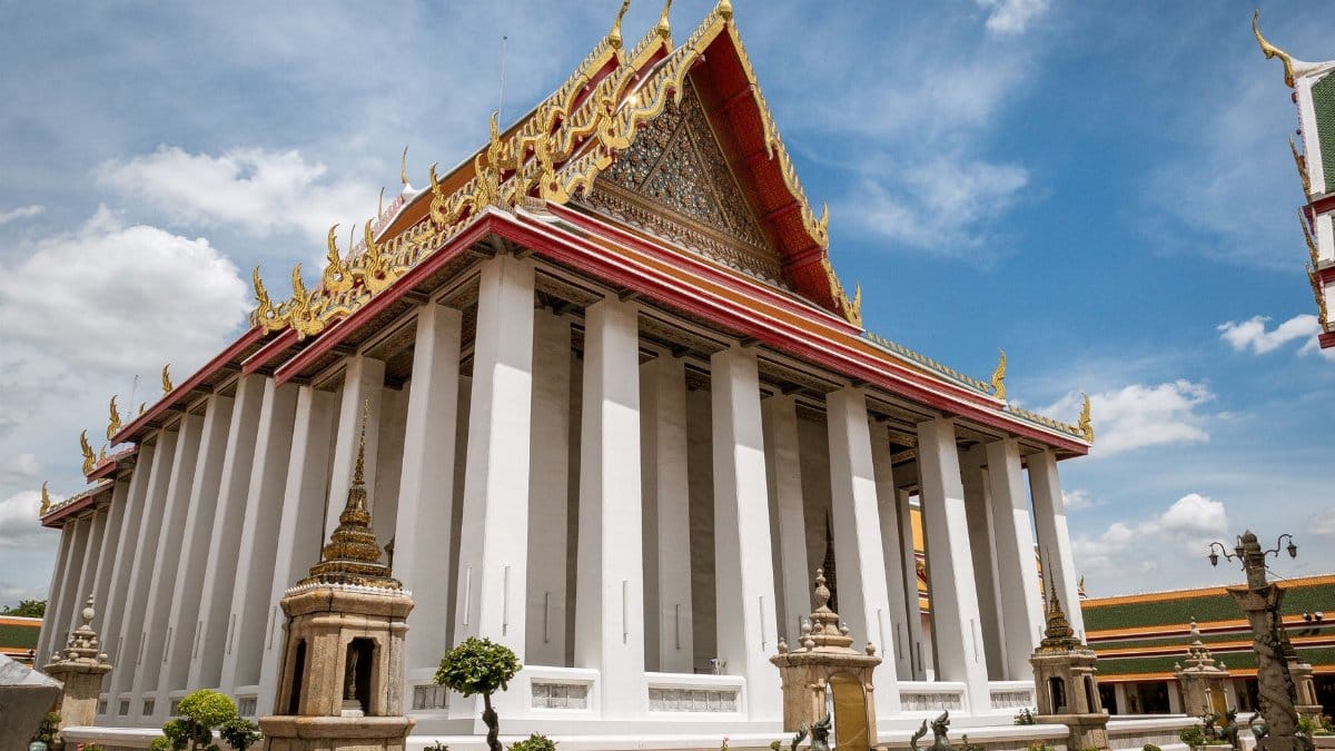 Stunning view of the Wat Pho Ordination Hall with bright blue sky in Bangkok, Thailand.