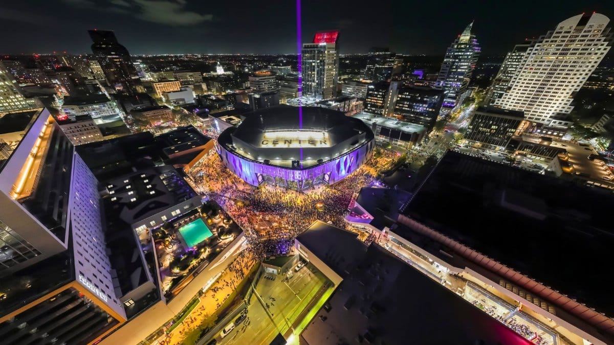 Aerial view of the illuminated Golden 1 Center and bustling downtown Sacramento at night.