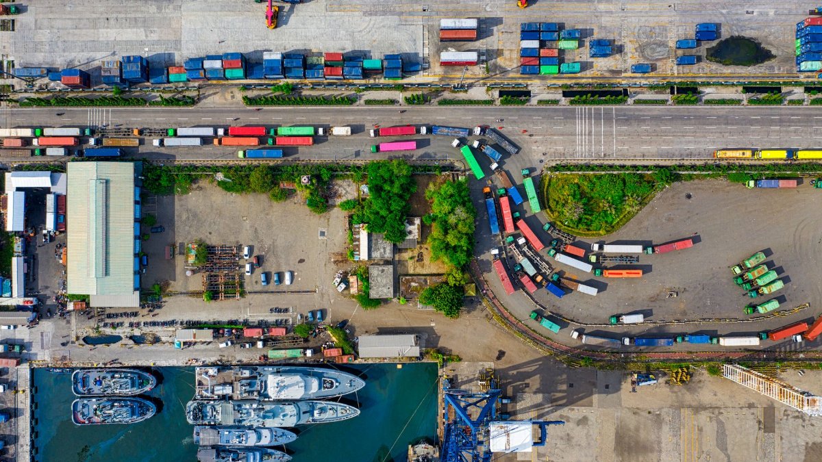 A vibrant aerial view of an industrial port with cargo containers in North Jakarta, Indonesia.