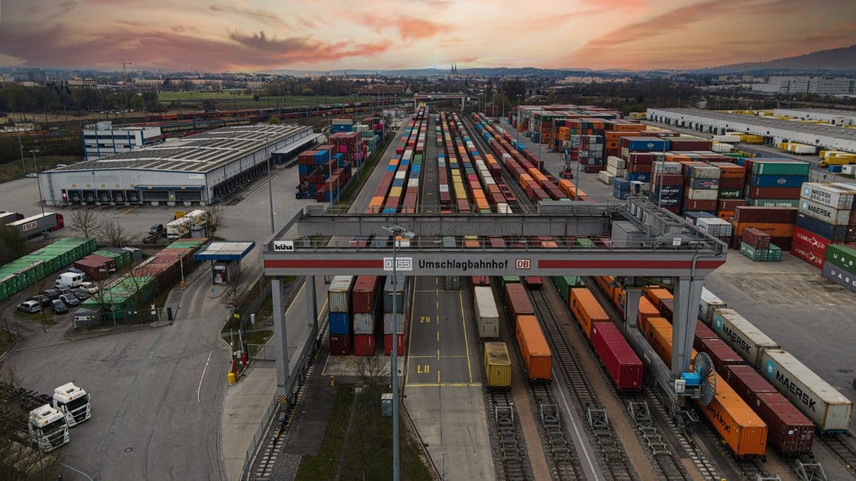 Aerial view of a bustling shipping yard with colorful containers at sunset, highlighting logistics.
