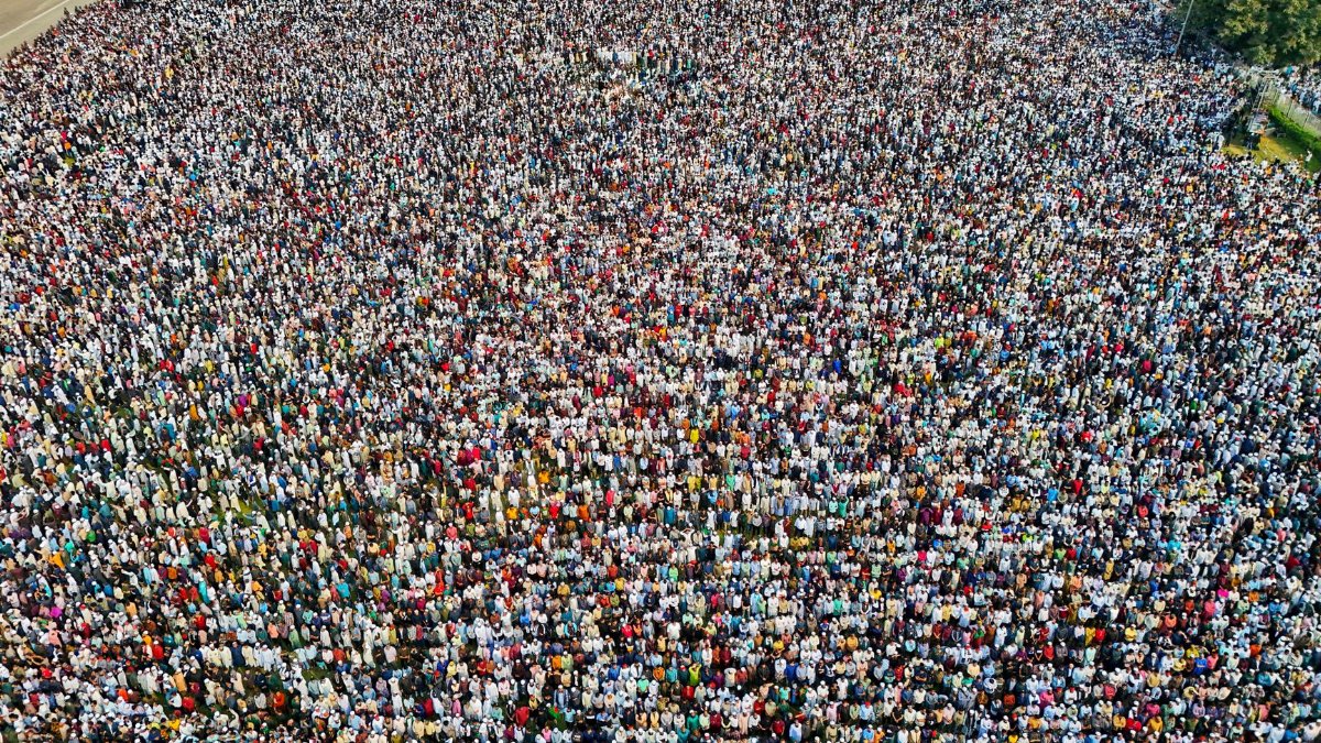 Aerial shot of a large crowd assembling outdoors in Dhaka, Bangladesh for a communal event.