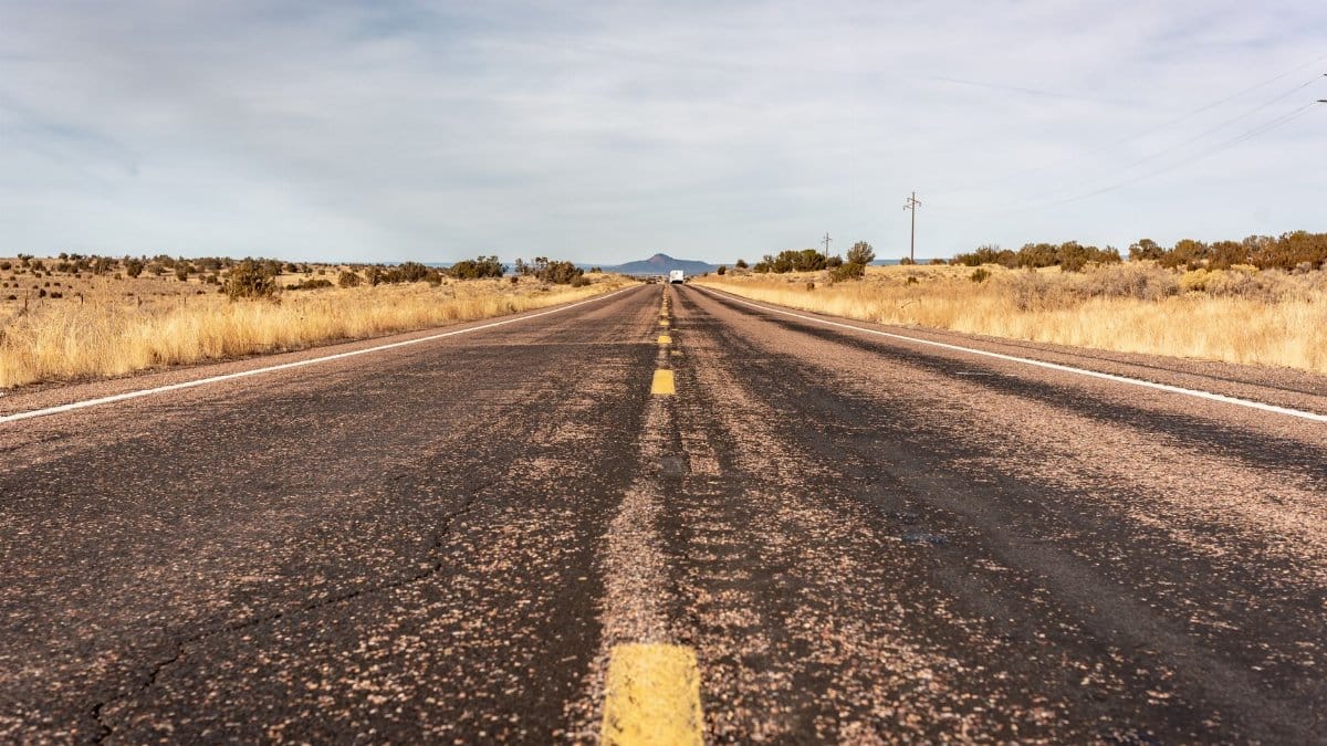 Long desert highway stretching into the horizon in Arizona, USA.