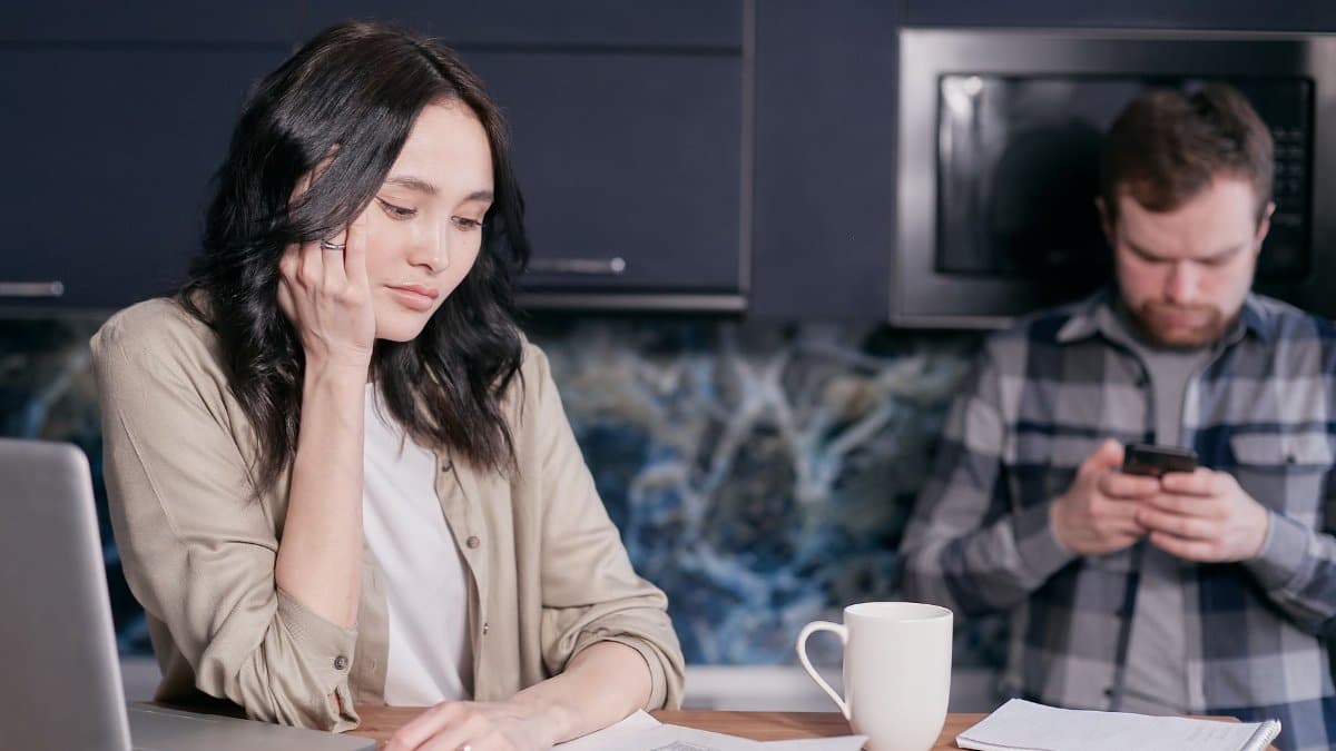 Couple experiencing stress while managing household finances at home.