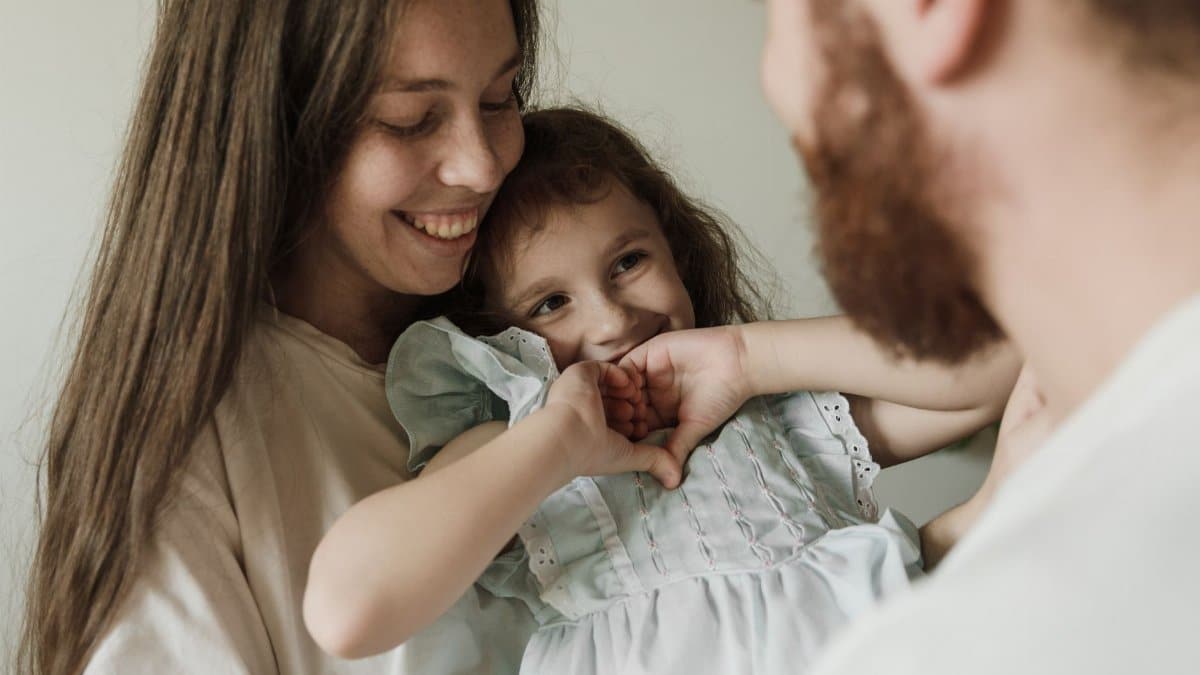 Heartwarming family portrait of mother and daughter embracing joyfully indoors.