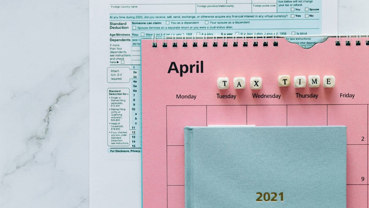 April calendar with tax forms, highlighting tax time reminders for financial tasks.
